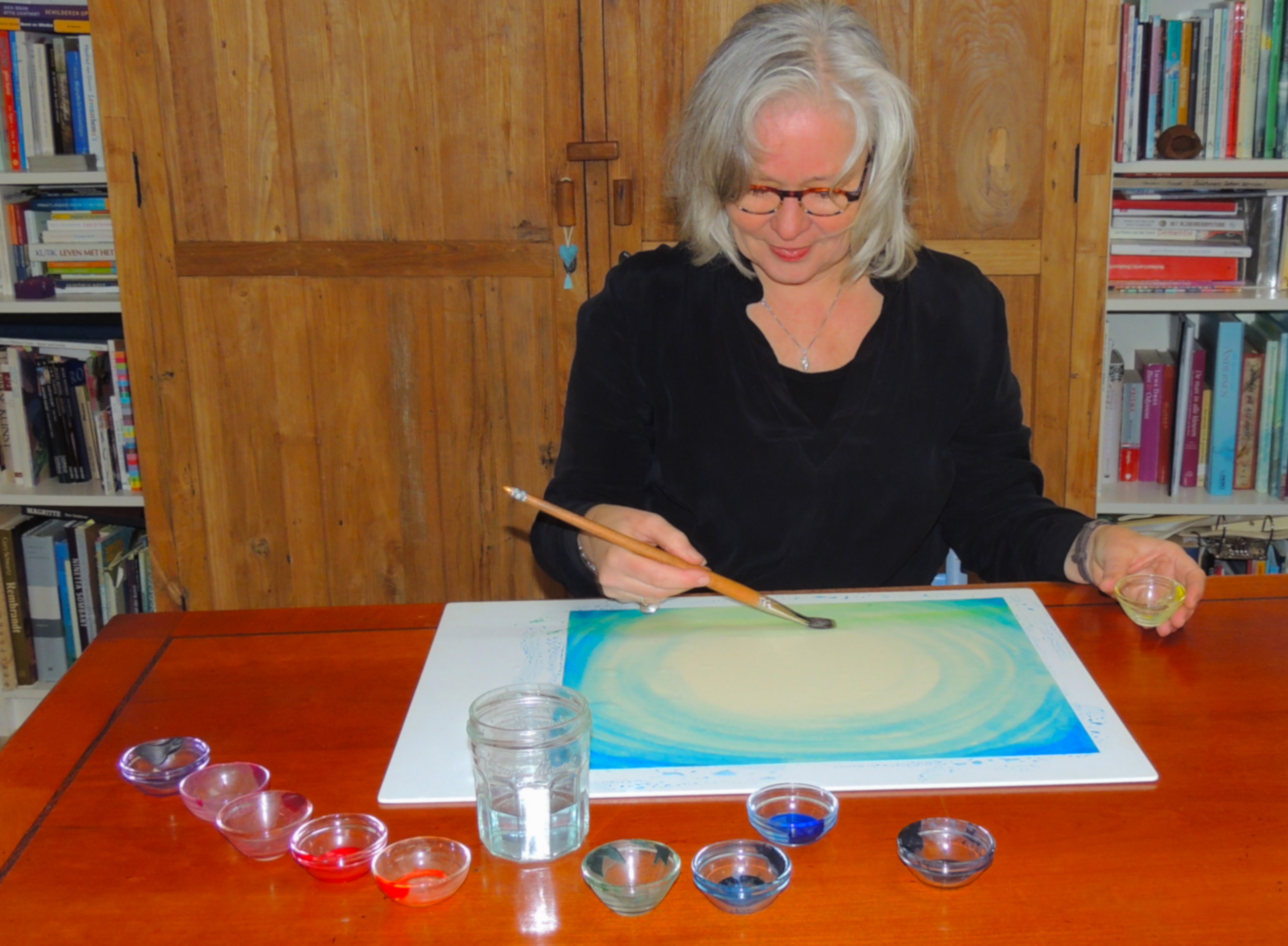 Pauline (ik) schilderent in mijn atelier aan tafel.